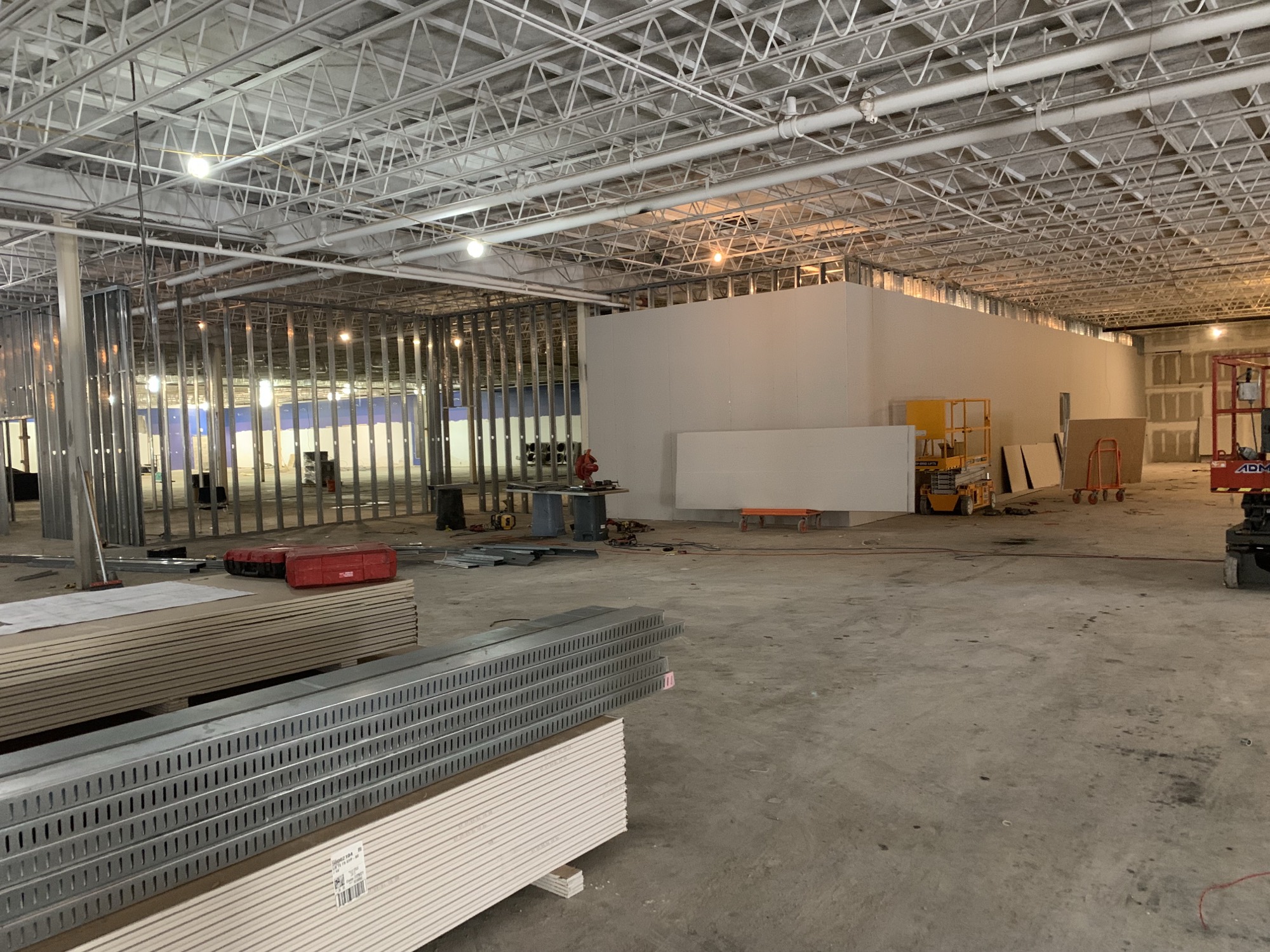 Interior metal stud framing and drywall in progress inside an occupied facility