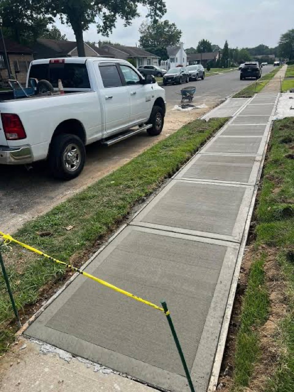 New concrete sidewalk sections curing beside a work truck